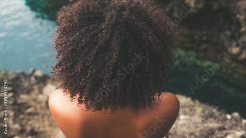 Black woman with afro hair on a Caribbean cliff