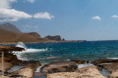  sea ​​shore and waves on the surface and rocks on the shore during the day and clouds in the sky
