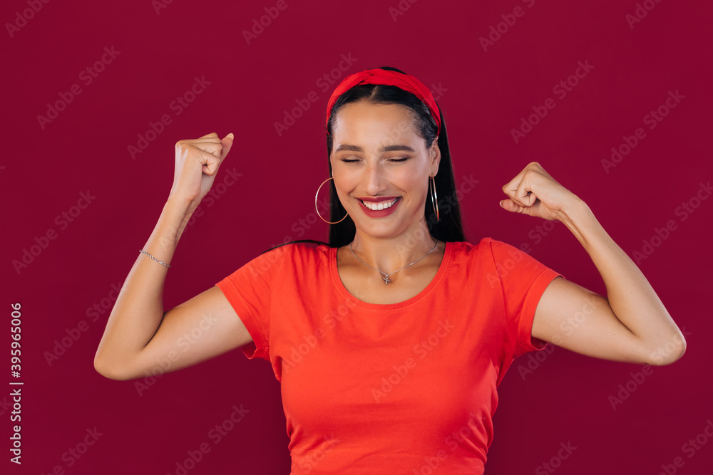 beautiful woman in casual clothes celebrating her victory raising hands clenching fists having happiness and satisfaction. Reaching goals and aims. beautiful woman in casual clothes celebrating her victory raising hands clenching fists having happiness and satisfaction. Reaching goals and aims.