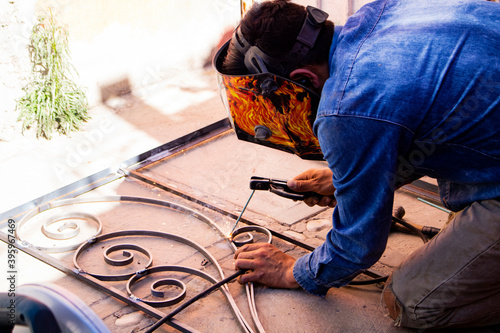 man working on the floor welding a iron ornament  photo