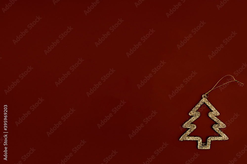 Obraz premium Minimalistic golden Christmas tree on a brown background. New year simple composition. Merry Christmas and happy New Year greeting card.