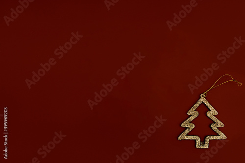 Minimalistic golden Christmas tree on a brown background. New year simple composition. Merry Christmas and happy New Year greeting card.