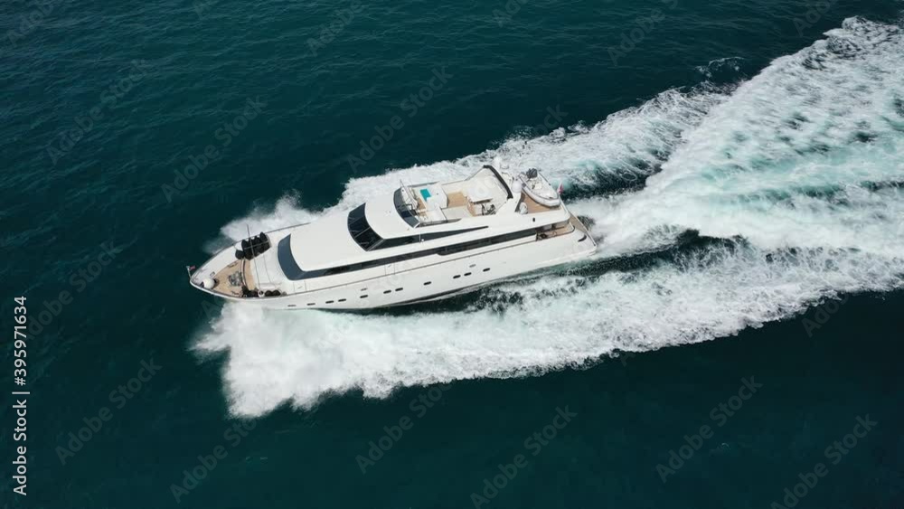 Aerial tracking top down video of luxury yacht cruising in deep blue open ocean sea