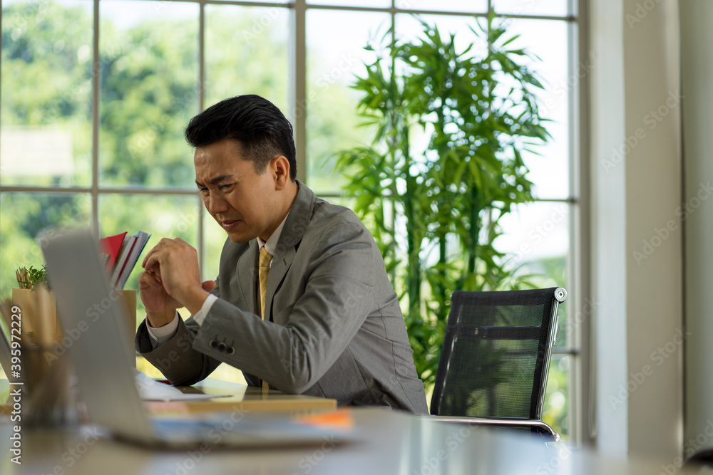 depressed worry Asian businessman wearing formal suit in the office feeling stressful from financial problem caused by virus pandemic. depressed worry Asian businessman wearing formal suit in the office feeling stressful from financial problem caused by virus pandemic.