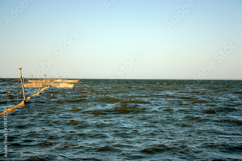 Fishing nets in the sea. The sun illuminates the fishing nets at sunset. Light excitement of the sea on a summer day.