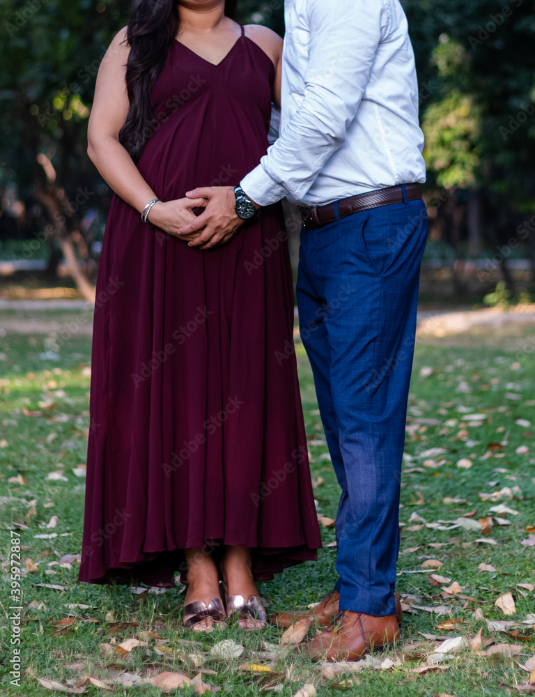 Indian pregnant lady with husband posing in park. Pregnancy pregnant future mother photoshoot. Motherhood photo.
