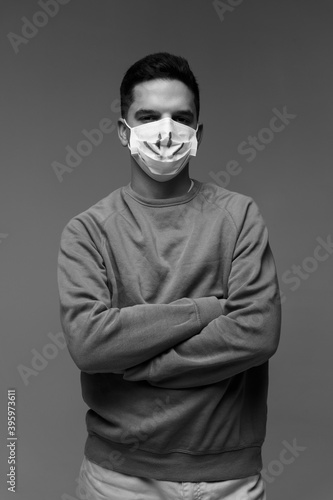 Portrait of man with protective face mask, looking at camera with sad smile
