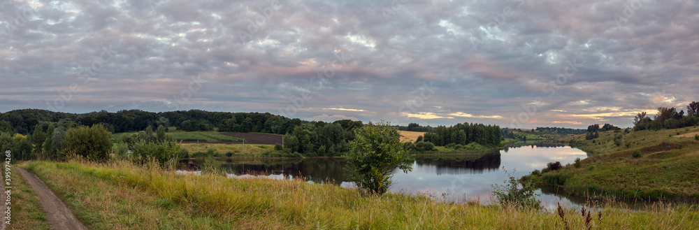 Tranquil summer landscape with river and green hills during cloudy morning Tranquil summer landscape with river and green hills during cloudy morning