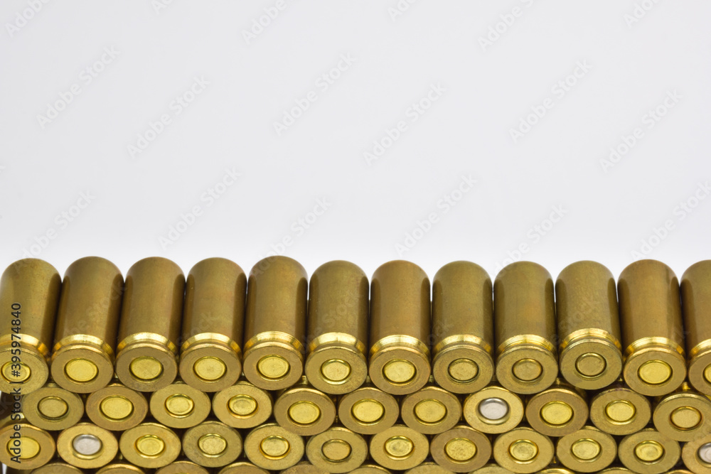 Rows of cartridge cases close-up. There is space above them for an inscription on a white background. Rows of cartridge cases close-up. There is space above them for an inscription on a white background.
