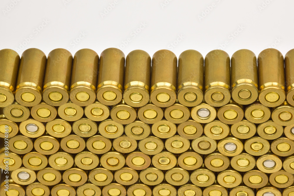 Rows of cartridge cases close-up. There is space above them for an inscription on a white background. Rows of cartridge cases close-up. There is space above them for an inscription on a white background.
