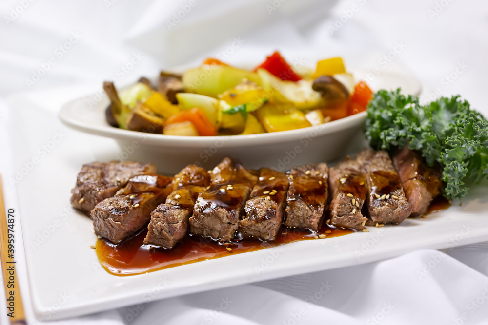 A view of a plate of beef teriyaki, in a restaurant or kitchen setting. A view of a plate of beef teriyaki, in a restaurant or kitchen setting.