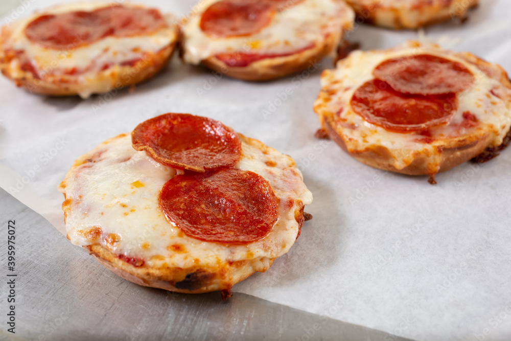 A view of bagel pizzas, featuring cheese and pepperoni toppings. A view of bagel pizzas, featuring cheese and pepperoni toppings.