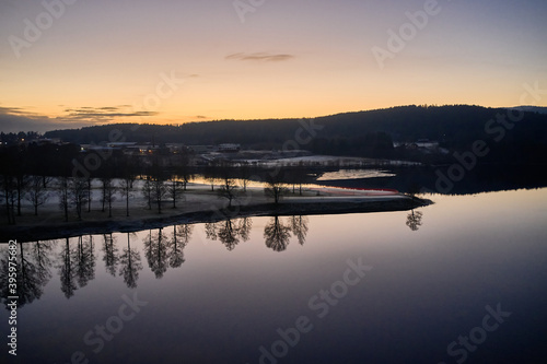 Drone or aerial photo from Oslo, Norway. Shot in late November in blue hours. Winter is coming. Ground and trees are covered with snow frost, the lakes are freezing up. © SteinOve