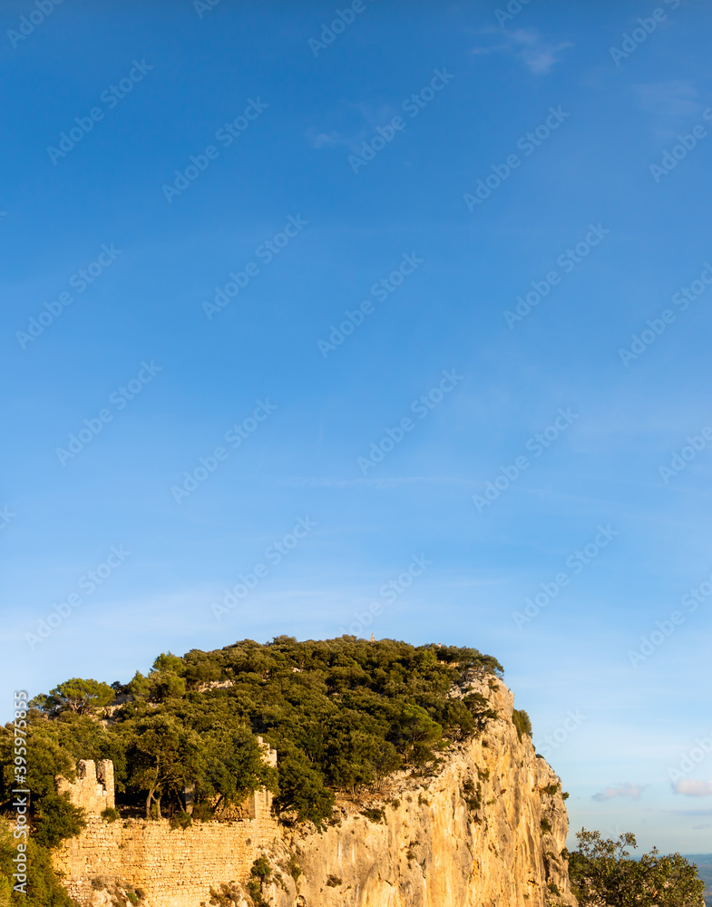 Top of a mountain with a green forest with a blue sky. Mediterranean forest