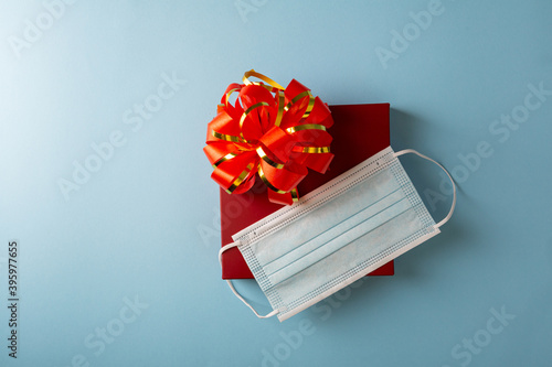Red gift box with bow and face mask, healthy holiday concept
