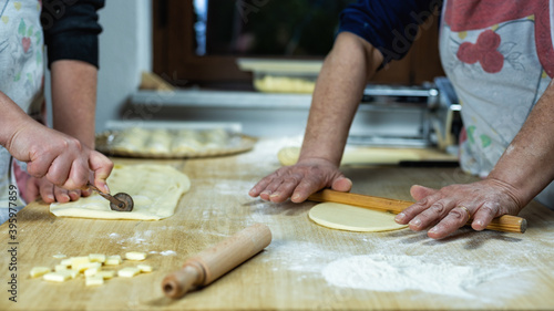 Close-up of woman's hands working the dough to prepare cheese ravioli. Traditional Sardinian cuisine. Homemade.