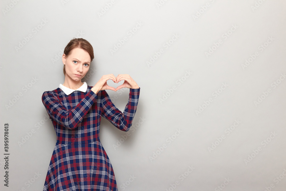 Portrait of unhappy girl making heart gesture with hands Portrait of unhappy girl making heart gesture with hands