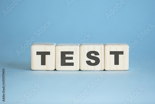 Test . concept. Word test written with wooden cubes. Education, medical , quality control. Blue background