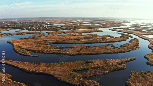 Top view of the beautiful Samarskie Plavni on the Dnieper with a village nearby in the warm evening light. Aerial UHD 4K drone realtime video, shot in 10bit HLG and colorized photo