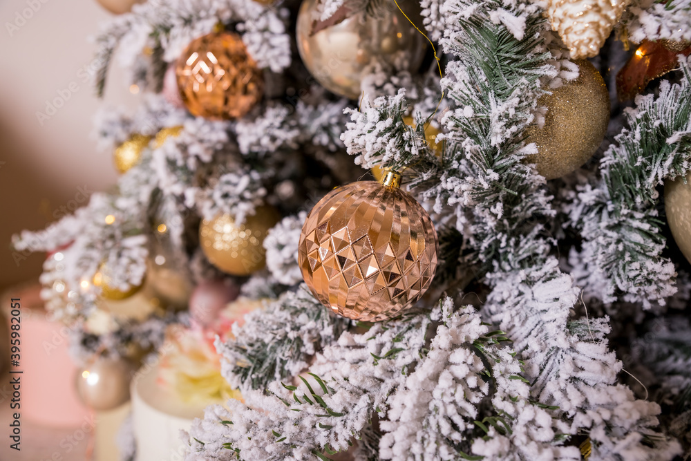 Christmas tree decorated with toys in gold and pink color. Christmas ornaments,ribbons, stick figure deer, beads and lights glowing garland. Winter Holiday.Luxury new year decor. Christmas tree decorated with toys in gold and pink color. Christmas ornaments,ribbons, stick figure deer, beads and lights glowing garland. Winter Holiday.Luxury new year decor.