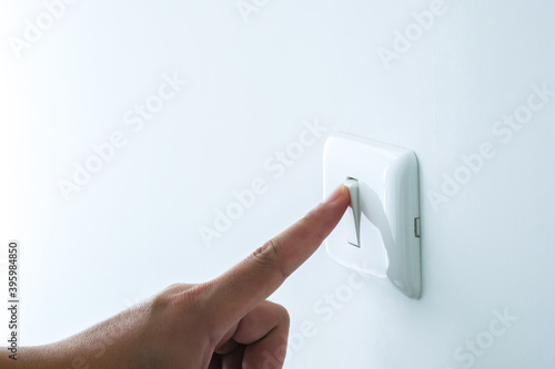 Close up people left hand pushing turn on or off light switch in the room. Copy space