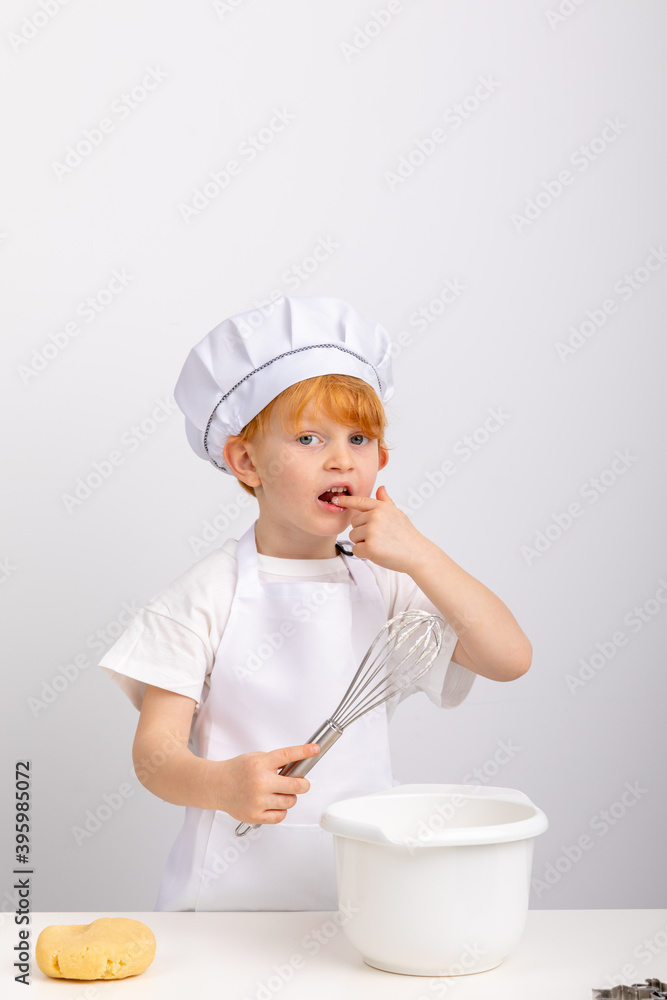 Junge mit roten Haaren hat Spaß beim Plätzchen backen. Junge mit roten Haaren hat Spaß beim Plätzchen backen.