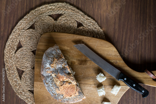 Food preparation: fresh bread sliced and cubed for Thanksgiving stuffing on cutting board with bohemian place mat and knife