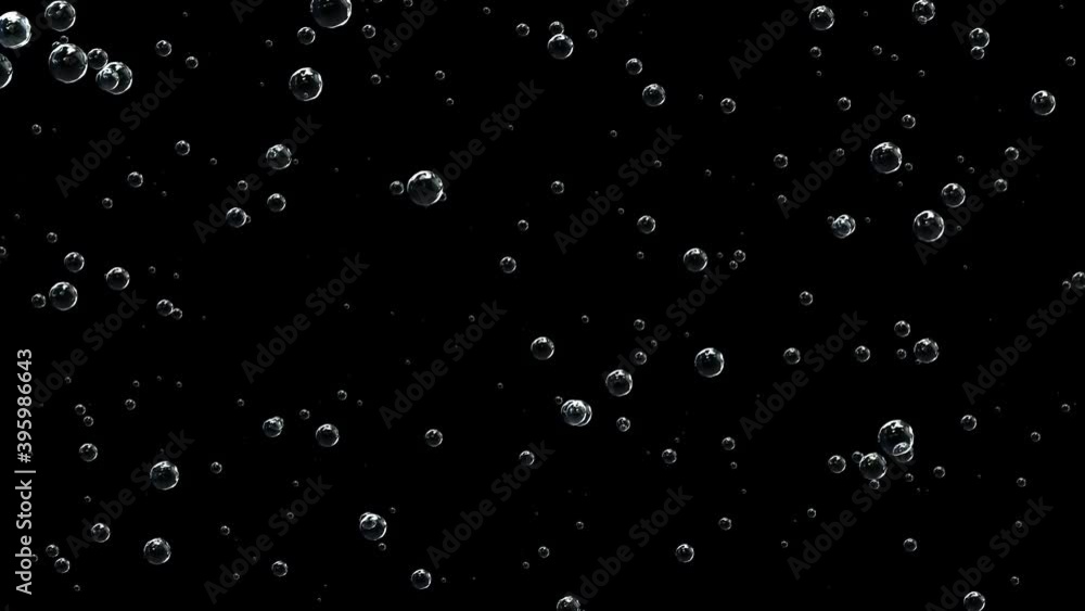 Bubbles of champagne rises rapidly against a black background. Bubbles of champagne rises rapidly against a black background.