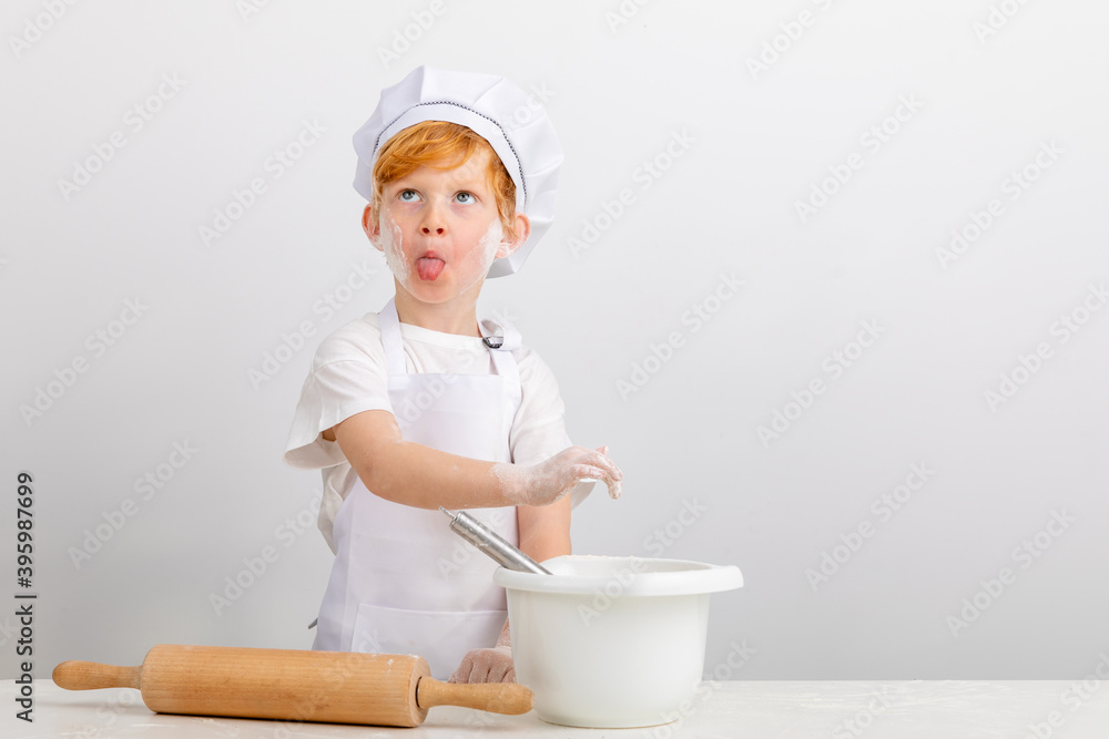 Junge mit roten Haaren hat Spaß beim Plätzchen backen. Junge mit roten Haaren hat Spaß beim Plätzchen backen.