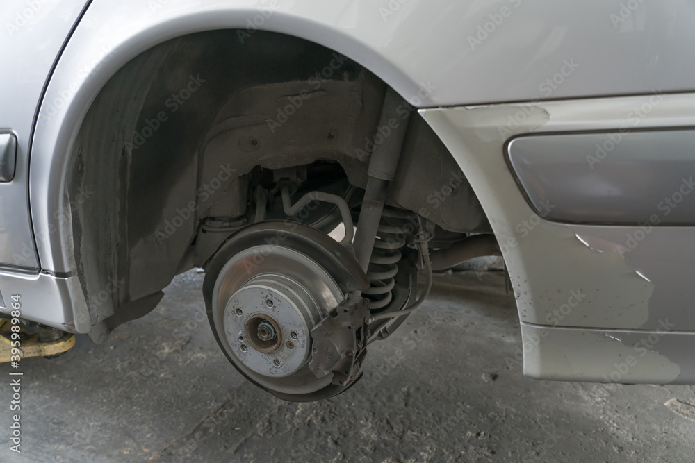 Φωτογραφία Passenger car on lifter in garage for inspect or service rear suspension and disc brake, caliper, lining, bush, tie rod, bearing and shock absorber