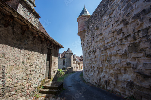 Narrow Path Between Two Stone Walls in the Medieval Village of Curemonte in the Nouvelle-Aquitaine Region in Central France photo