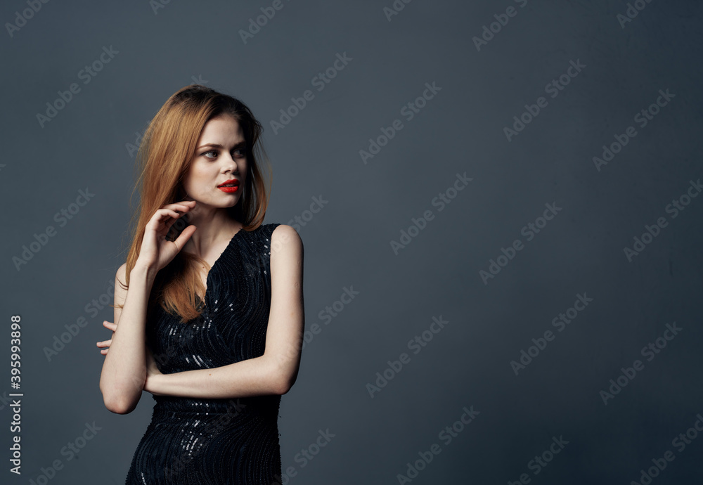 Fototapeta premium Beautiful woman in black dress red hair gray background Copy Space Model