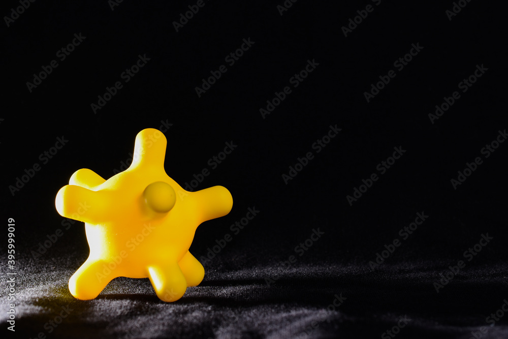 Obraz premium Yellow colorful bright isolated spiky ball toy on a black background, macro