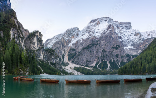A panoramic view of the lake Pragser Wildsee in the Dolomites with a chain of boats, mountains and woods in autumn in South Tyrol, Italy. © Alexander