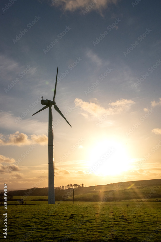 Obraz premium a wind turbine spinning in the sunset providing clean green energy