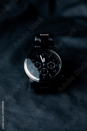 Reloj de pulsera negro elegante sobre fondo negro. Accesorios para hombre.