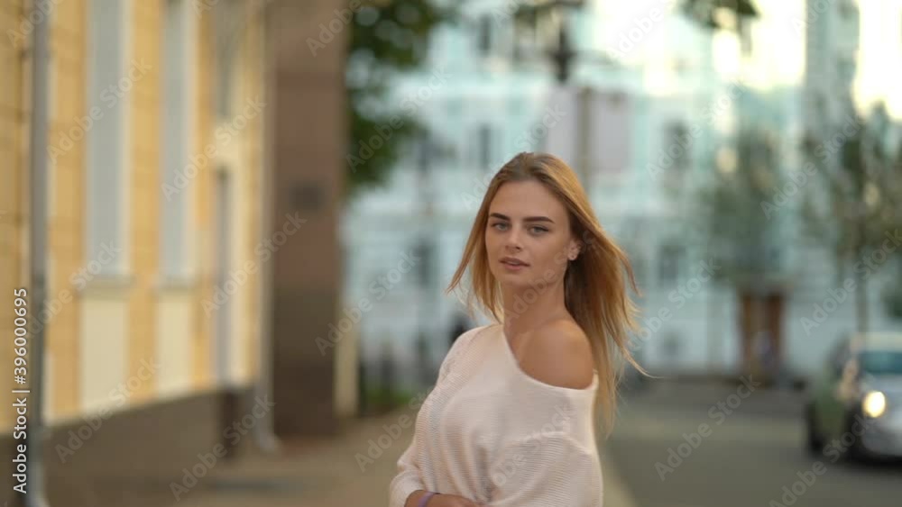 Beautiful girl walking down the street with a smile. Slow motion Beautiful girl walking down the street with a smile. Slow motion