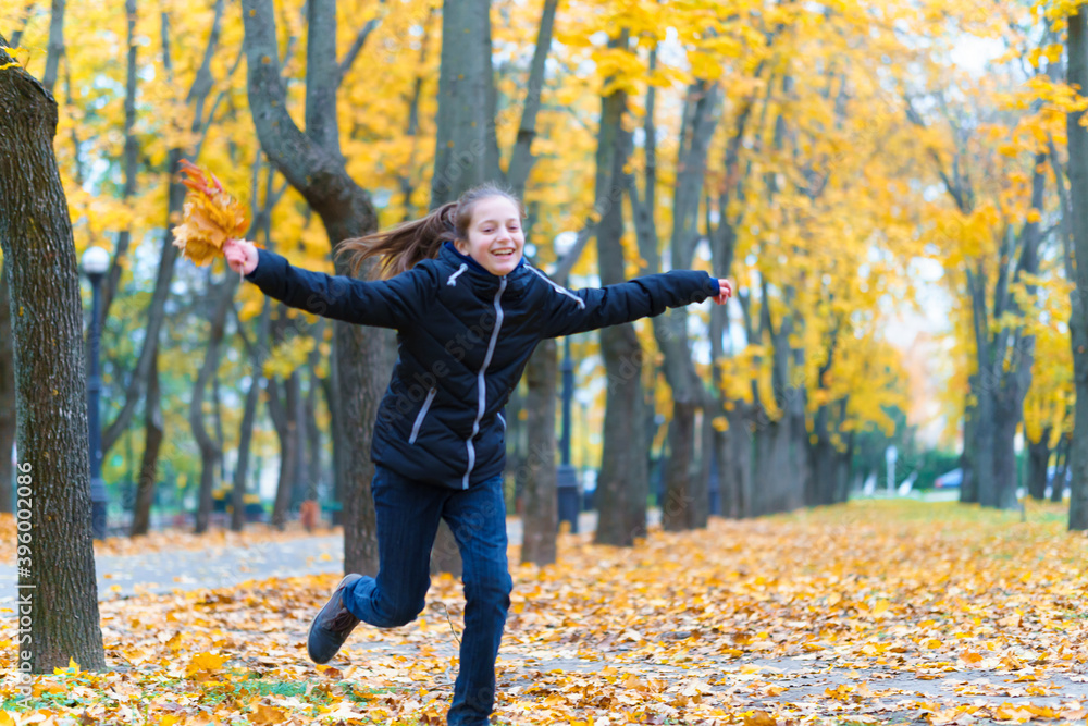 a girl running through the park and enjoys autumn, beautiful nature with yellow leaves a girl running through the park and enjoys autumn, beautiful nature with yellow leaves