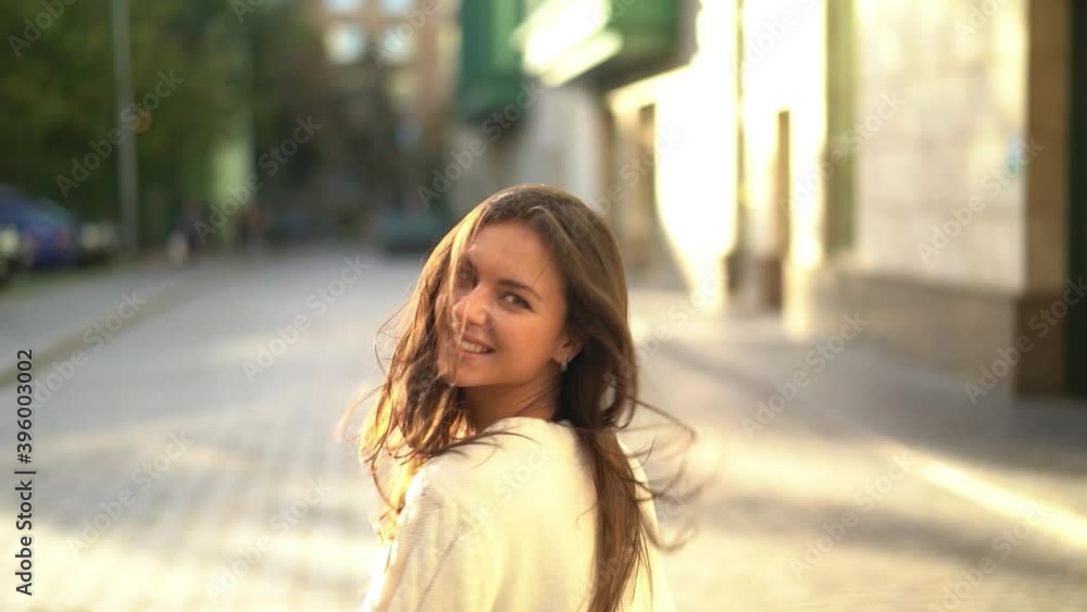 Beautiful girl with a smile on the background of the city. Slow motion Beautiful girl with a smile on the background of the city. Slow motion