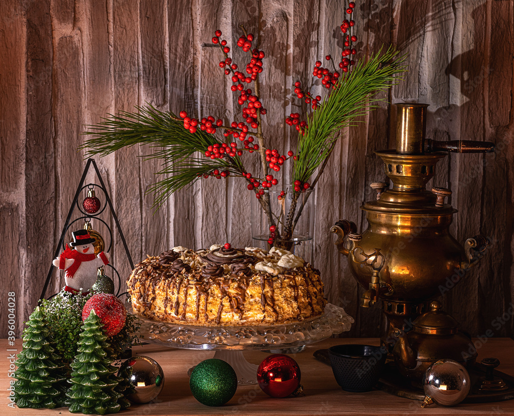 
Cake on a crystal stand, Christmas tree decorations, and flowers on the table.Very beautiful background.