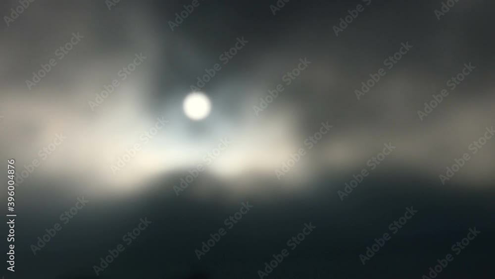 Dark, moody clouds drifting past bright sun. Defocused. Dark, moody clouds drifting past bright sun. Defocused.