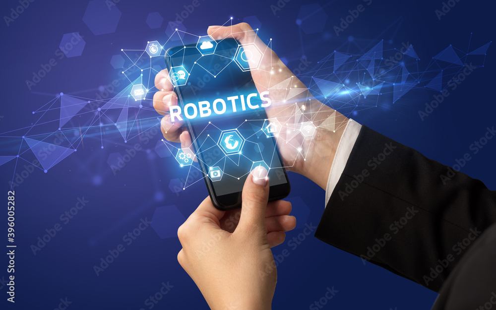 Female hand holding smartphone with ROBOTICS inscription, modern technology concept Female hand holding smartphone with ROBOTICS inscription, modern technology concept