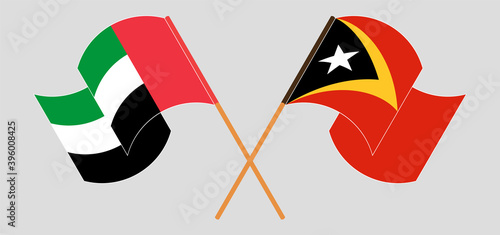 Crossed and waving flags of United Arab Emirates and East Timor