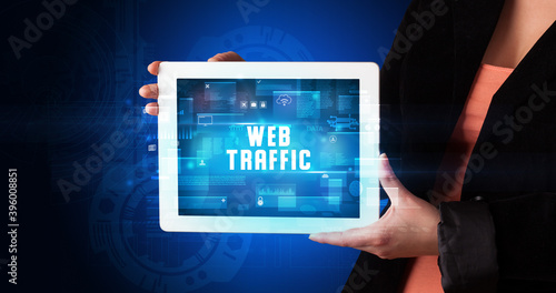 Wallpaper Mural Young business person working on tablet and shows the digital sign: WEB TRAFFIC Torontodigital.ca