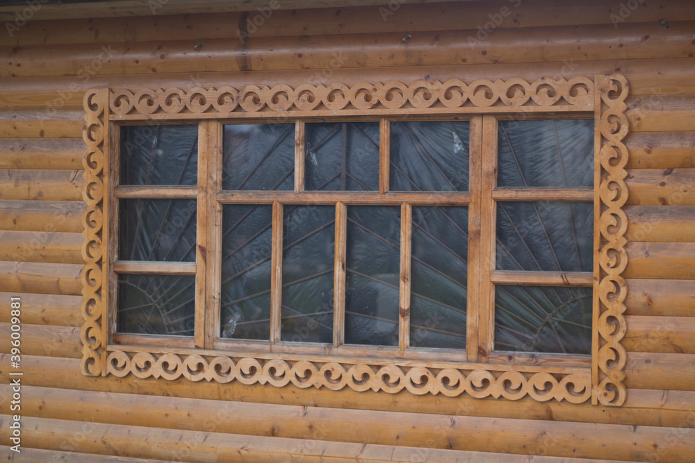 Wooden window with platband. Patterned platband made of wood