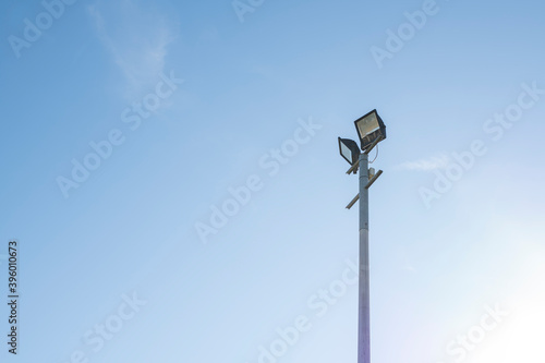 pillar with two projectors against a blue sky