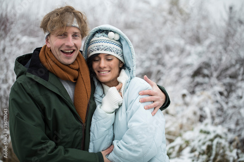 Happy Young Couple in Winter Park having fun. Family Outdoors. Couple in love. Snow. Background. 
