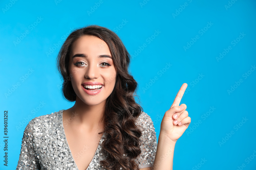 Beautiful young woman wearing elegant dress on blue background. Christmas party Beautiful young woman wearing elegant dress on blue background. Christmas party
