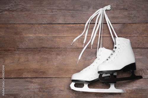 Pair of skates hanging wooden background. Space for text photo