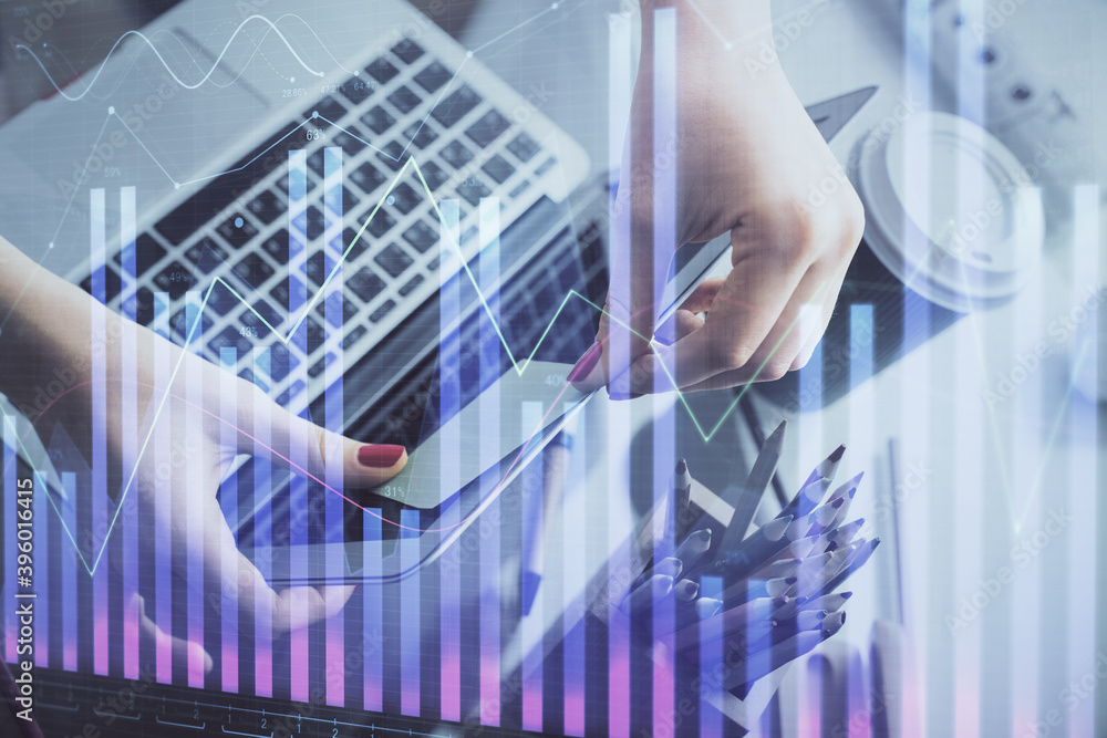 Double exposure of businesswoman hands typing on computer and financial graph hologram drawing. Stock market analysis concept. Double exposure of businesswoman hands typing on computer and financial graph hologram drawing. Stock market analysis concept.